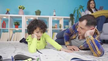 Parent father helping tired, upset boy having difficulty in homeschooling learning. Father comforting his sad boy, encouraging him to help him study and learn. video