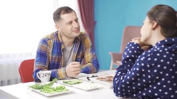 content et aimant marié couple. romantique homme compliments le sien épouse. charmant marié couple fabrication l'amour à petit déjeuner table dans le Matin. video