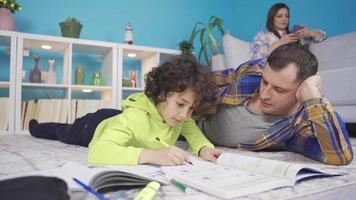 Family man helping boy at home with his lessons. Successful and smart kid. Father helping his son with school homework. Education and relationship, male teaching and boy learning concept. video