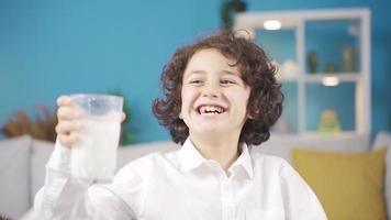 detailopname van schattig en knap jongen voor melk. slim en knap jongen drinken melk en lachend. video