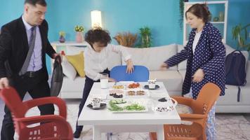 le dévoué mère qui prépare petit déjeuner pour sa mari qui va à travail et sa peu garçon qui va à école aide leur et fait du leur heureux. video