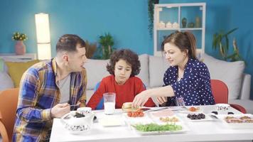 mam en jongen zijn maken pret van hun vader en hebben plezier. gelukkig en vrolijk familie maken elk andere lach en hebben pret Bij ontbijt. video