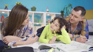 Happy family parents helping boys with homework. Education and training concept. The cultured and modern family parents help their sons with their lessons at home. video