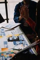 Close up ux developer and ui designer use augmented reality brainstorming about mobile app interface wireframe design on desk at modern office.Creative digital development agency photo