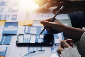 Close up ux developer and ui designer use augmented reality brainstorming about mobile app interface wireframe design on desk at modern office.Creative digital development agency photo