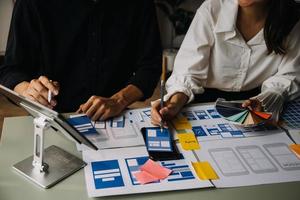 Close up ux developer and ui designer use augmented reality brainstorming about mobile app interface wireframe design on desk at modern office.Creative digital development agency photo