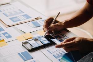 Close up ux developer and ui designer use augmented reality brainstorming about mobile app interface wireframe design on desk at modern office.Creative digital development agency photo