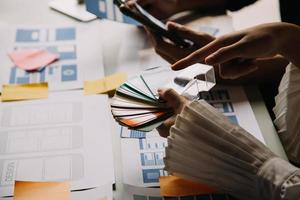 Close up ux developer and ui designer use augmented reality brainstorming about mobile app interface wireframe design on desk at modern office.Creative digital development agency photo
