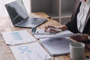 mujer de negocios o contadora que trabaja en inversiones financieras en calculadora, cálculo, análisis de negocios y crecimiento de marketing en gráficos de datos de documentos financieros, contabilidad, concepto económico y comercial. foto