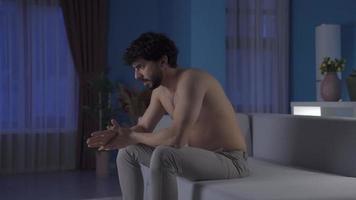 Side view of stressed and depressed naked man. Young man with handsome and fit body is depressed and unhappy at home. video