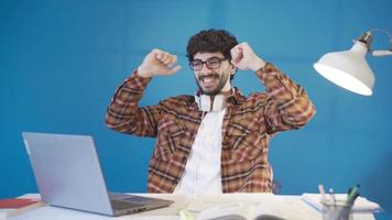 exitoso masculino estudiante mirando a ordenador portátil pantalla alegría. el Universidad estudiante quien mira a el examen resultados es contento por consiguiendo alto Los grados. video