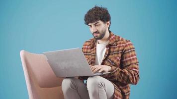 bonito feliz jovem homem digitando uma texto usando computador portátil, aluna fazendo trabalho de casa, criativo jovem homem rabiscar baixa Novo Ideias. video