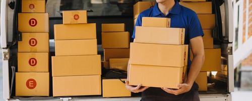Asian business men use laptop computer checking customer order online shipping boxes at home. Starting Small business entrepreneur SME freelance photo