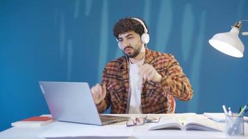 The unsuccessful young man gets angry and bored by what he sees on the laptop screen. Male student using laptop and looking at screen feeling sad, angry seeing bad news or failure. video