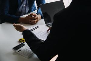 A car rental company employee is handing out the car keys to the renter after discussing the rental details and conditions together with the renter signing a car rental agreement. Concept car rental. photo