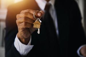 modelo de casa con agente de bienes raíces y cliente discutiendo por contrato para comprar casa, seguro o fondo de préstamo de bienes raíces. foto