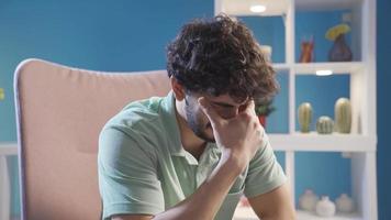 Emotional sad young man crying at home alone and not feeling well. Unhappy and hopeless depressed young man is crying and he hates it. video