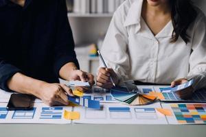 Close up ux developer and ui designer use augmented reality brainstorming about mobile app interface wireframe design on desk at modern office.Creative digital development agency photo