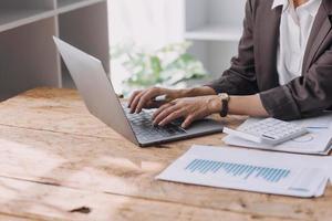 mujer de negocios o contadora que trabaja en inversiones financieras en calculadora, cálculo, análisis de negocios y crecimiento de marketing en gráficos de datos de documentos financieros, contabilidad, concepto económico y comercial. foto