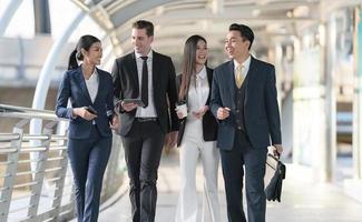 Business people walking and talk to each other in front of modern office photo