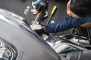 People are repairing a motorcycle Use a wrench and a screwdriver to work photo