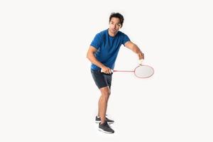 A badminton player in sportswear stands holding a racket and shuttlecock. photo