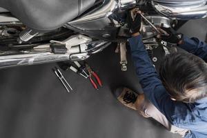 People are repairing a motorcycle Use a wrench and a screwdriver to work photo