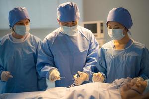 Doctor, nurse doing surgery on patient. photo