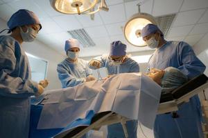 Doctor, nurse doing surgery on patient. photo