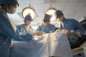 Doctor, nurse doing surgery on patient. photo