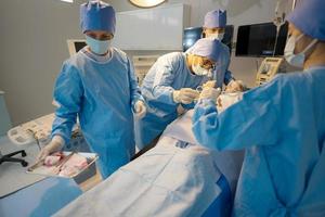 Doctor, nurse doing surgery on patient. photo