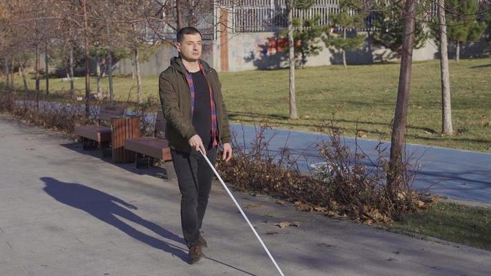 Blind man with a cane tells his wife his problem. Blind man at home sharing  his troubles with his wife. He has a walking stick and his wife is  listening to him.