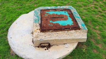 septis tanque agujero de hombre cubrir a un país cabaña en el patio de recreo foto