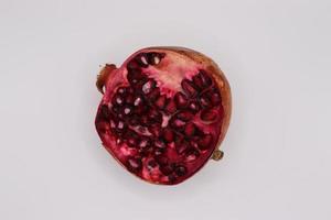 Red pomegranate cut  isolated on white background photo