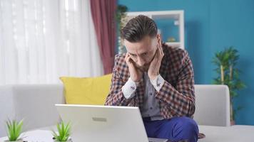 estressado homem de negocios trabalhando a partir de casa obtendo Bravo e entediado. homem de negocios trabalhando às casa usando computador portátil pega nervoso, coisas ir errado, ele pega mau notícias. video