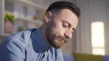 triste preocupado jovem masculino. homem tentando para acordo com psicológico problemas. estressado e pensativo homem às casa olhando por aí e sentindo-me depressivo. video