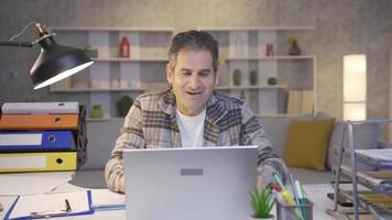 Mature man working in home office looking at laptop and clapping wow. Mature man looking at laptop is stunned by what he sees and applauding for congratulatory purposes. video