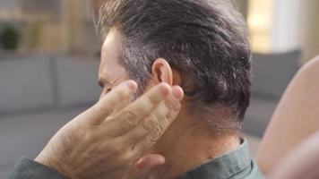 volwassen Mens met zeer oren wrijven zijn oor met handen. volwassen Mens met gewond trommelvlies voelt pijn en lijdt van pijn. video