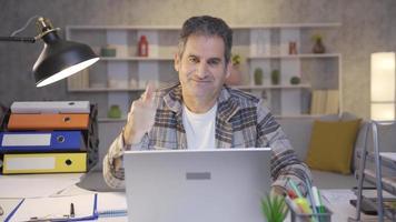 Successful home office worker mature man looking at camera and making ok sign. Motivated and cute mature man looking at camera and making ok sign. video