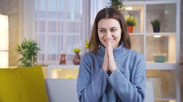 excité et animé portrait de content et mignonne Jeune femme sur canapé à maison. une Jeune femme qui est content avec une nouvelles ou un événement obtient excité et sourit. video