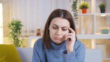 detailopname attent verward jong vrouw, maken beslissing, maken plan. jong vrouw zittend alleen Aan sofa Bij huis verloren in diep gedachten, proberen naar beslissen, verward. video