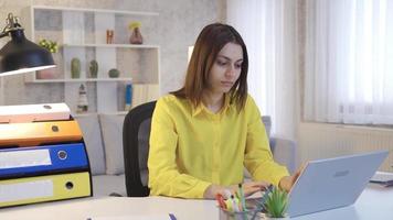 ritratto di imprenditore o donna d'affari giovane donna Lavorando a partire dal casa. contento e bellissimo giovane donna d'affari fare in linea opera a partire dal casa su il computer portatile e sorridente guardare a telecamera. video