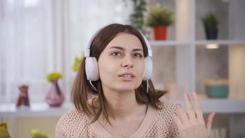 energético y ritmo bailando joven mujer escuchando a música con auriculares. positivo hembra o Universidad estudiante escuchando música con auriculares y relajante y bailando ritmo. video