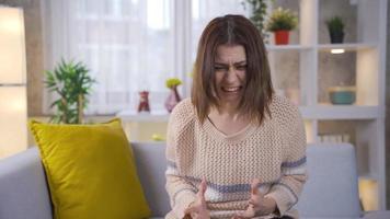 Depressed young woman gets angry, has a nervous breakdown, has psychological problems. Thoughtful young woman at home going crazy, shouting from psychological distress and having a burst of anger. video