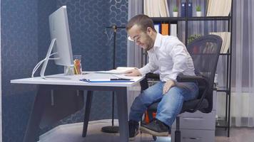 désactivée nain homme stressé par le sien emploi. il travaux dans le sien bureau. désactivée nain homme travail sur ordinateur dans le sien bureau, stressé et occupé. video