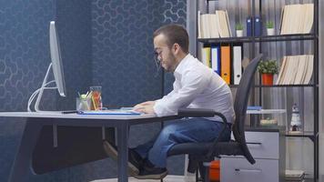 Disabled dwarf man rejoicing at the computer. Disabled midget man looking at computer in his office and rejoicing. video