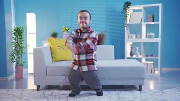 Young man with dwarfism dancing excitedly and pleasantly having fun at home. Disabled dwarf young man at home alone having fun, dancing wildly and in good spirits. video