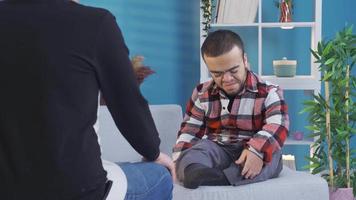 Frustrated sad disabled dwarf young man chatting with his best boyfriend at home. Young man with dwarfism shares his grief and sadness with his closest boyfriend. video
