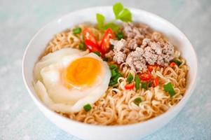 noodles bowl with boiled egg minced pork vegetable spring onion lemon on table food , instant noodles cooking tasty eating with bowl noodle soup photo