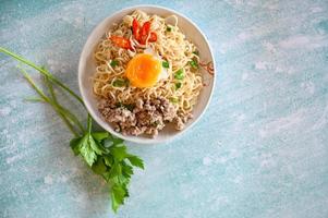 noodles bowl with boiled egg minced pork vegetable spring onion lemon on table food , instant noodles cooking tasty eating with bowl noodle soup photo